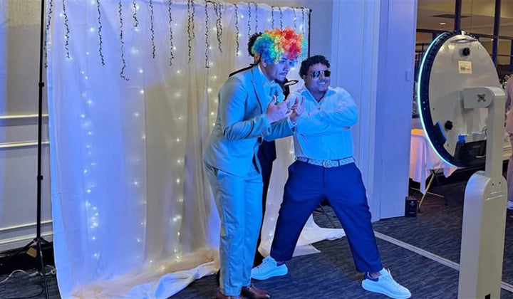 Two guests posing at an event photo booth setup, illustrating how to choose a target market for a photo booth business.