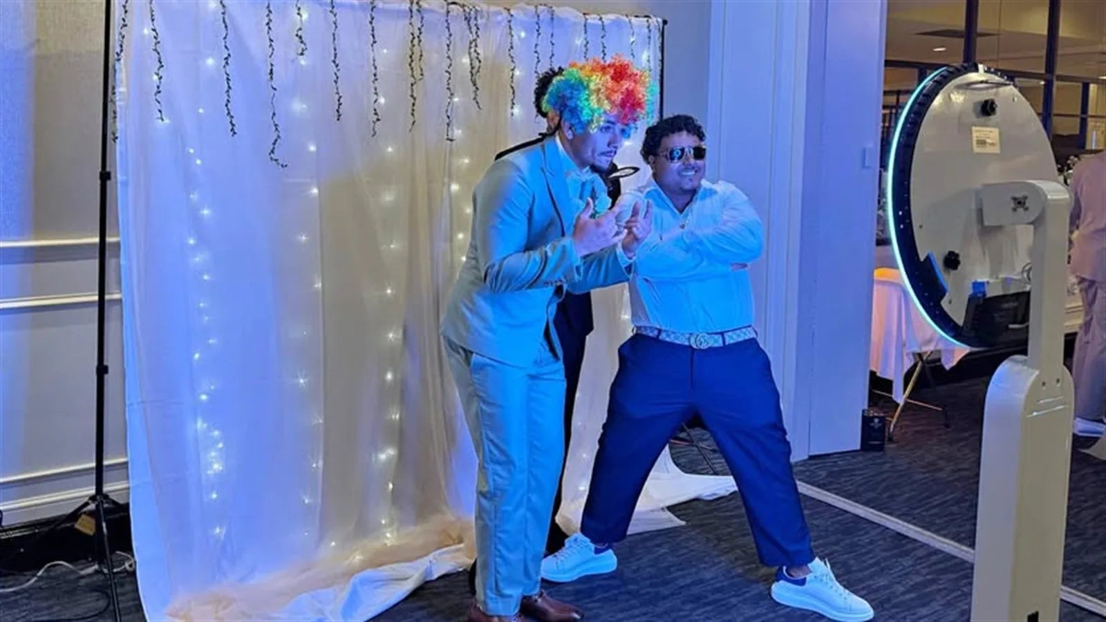 Two guests posing at an event photo booth setup, illustrating how to choose a target market for a photo booth business.