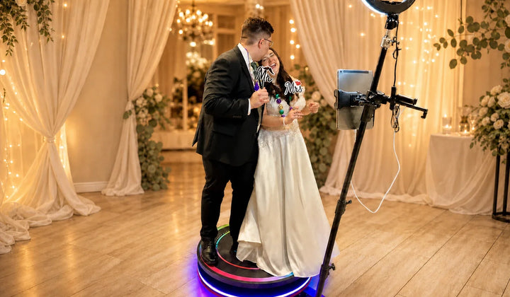 Bride and groom using a 360 photo booth at their wedding reception