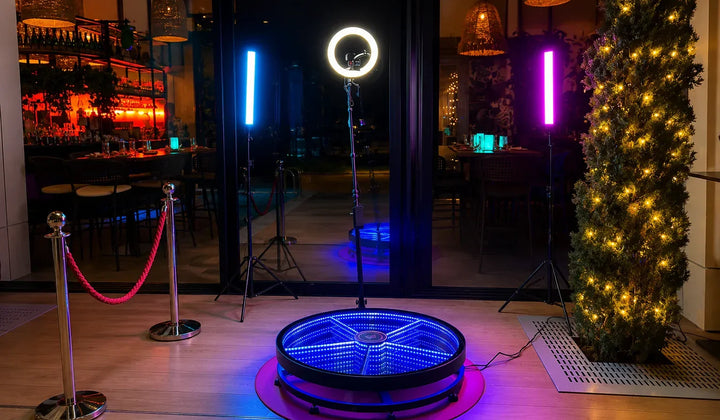 360 photo booth setup with illuminated platform and event lighting