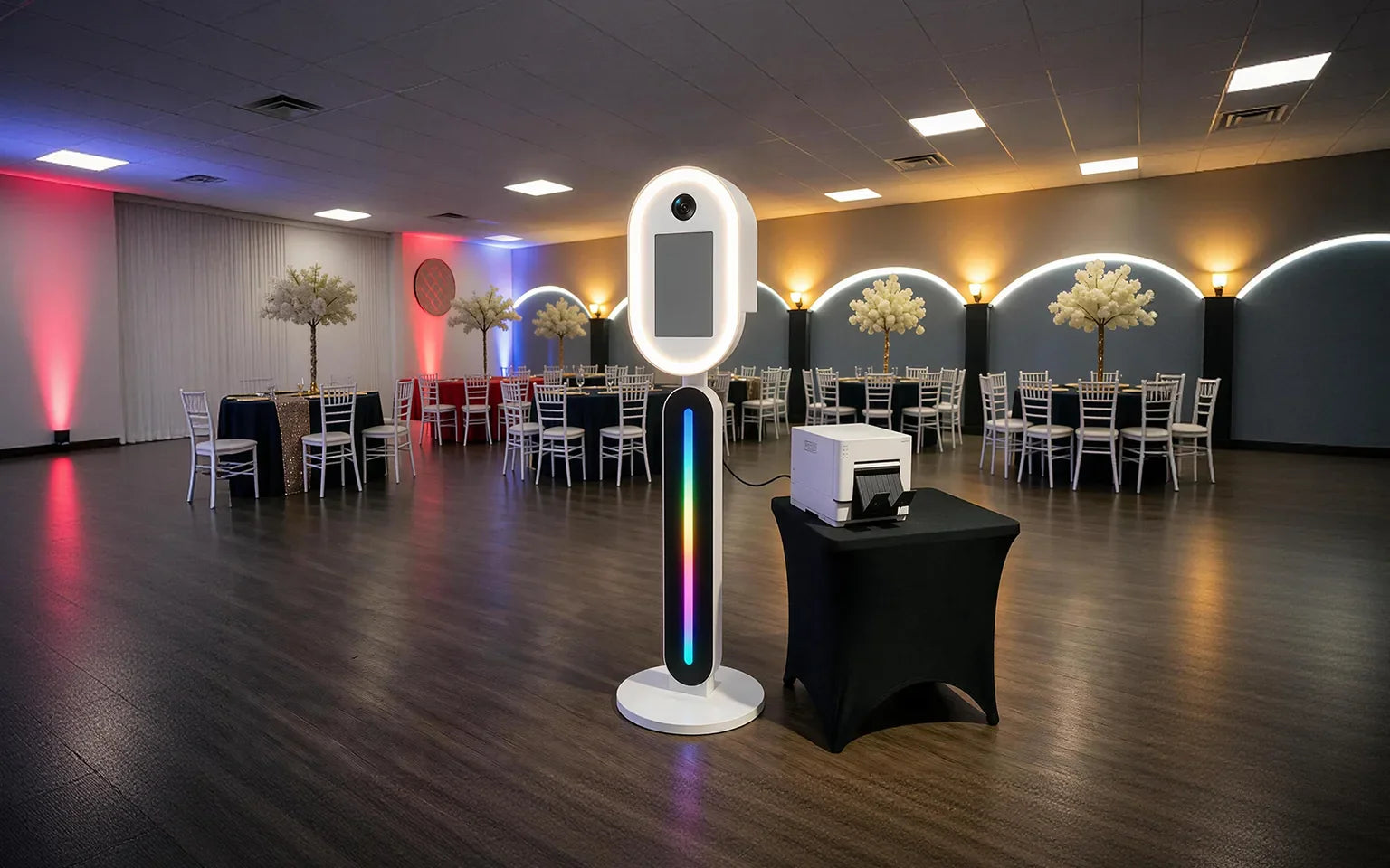 DSLR photo booth setup with camera, touchscreen, LED stand, and printer at an event venue