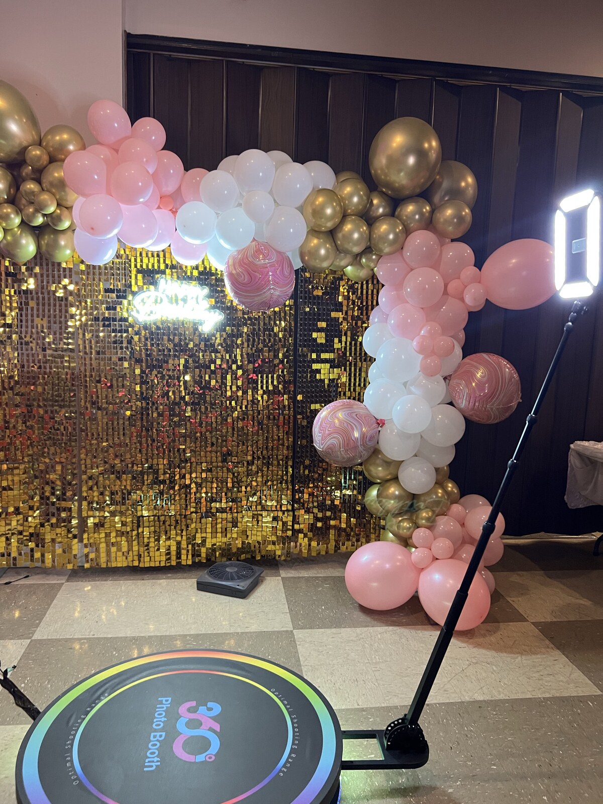 Spin Metal 360 photo booth at a party with a pink balloon backdrop.
