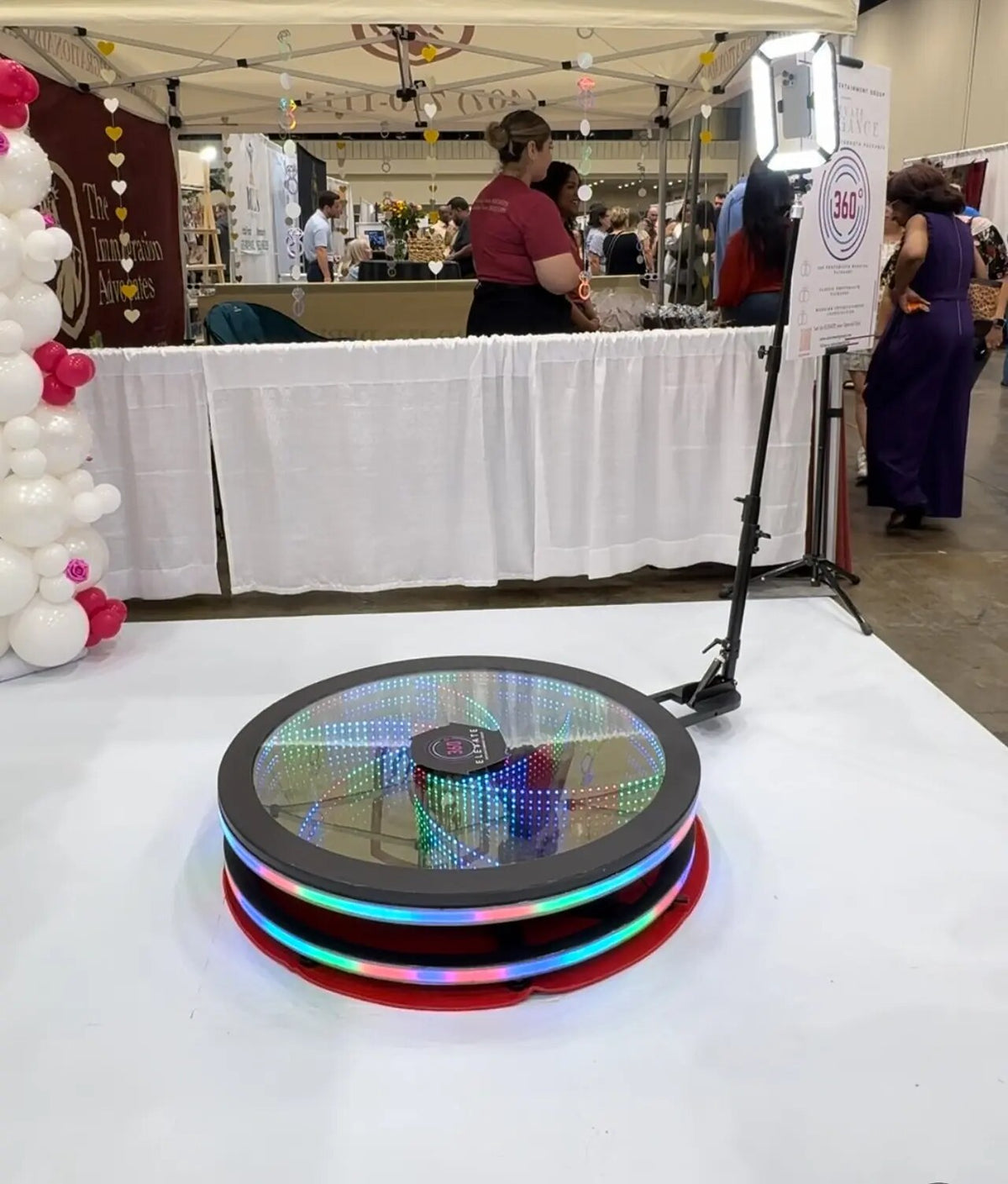 Spin Vortex glass 360 photo booth on a trade show floor.